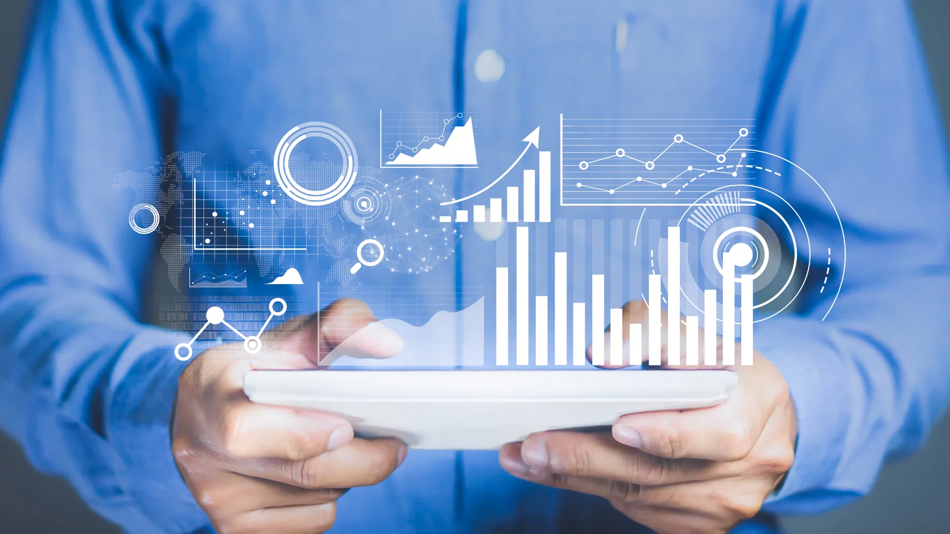 Persona con una tablet de la que salen gráficas de barras holográficas de business intelligence